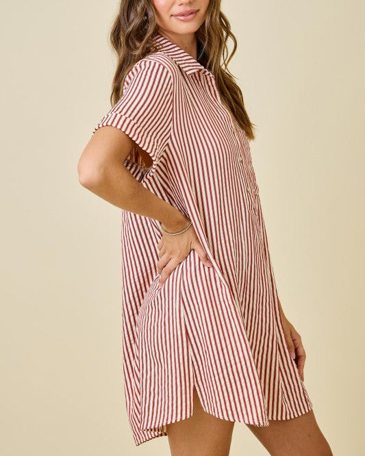 Woman wearing a red and white striped dress on a beige background