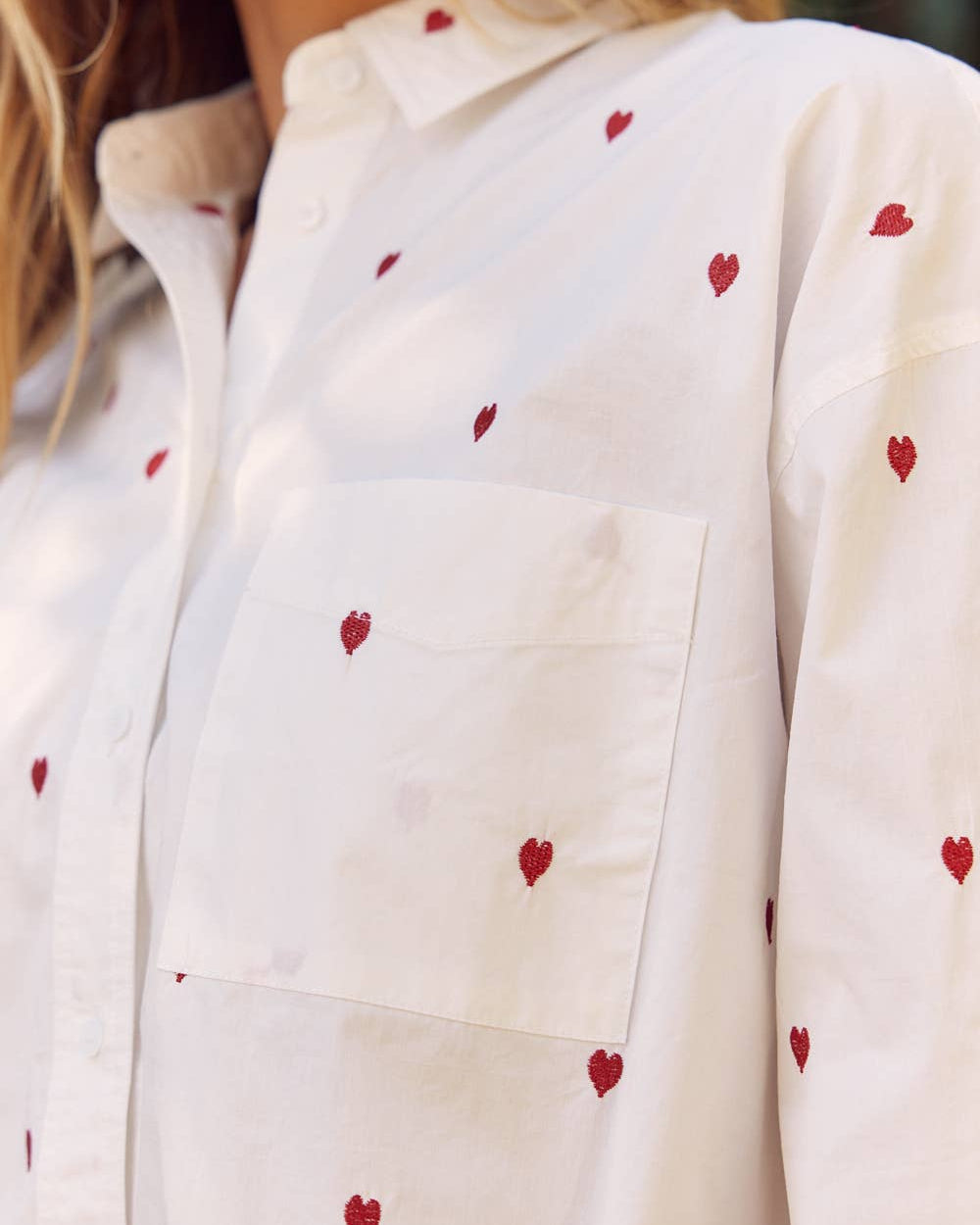 White shirt with red heart patterns worn by a person
