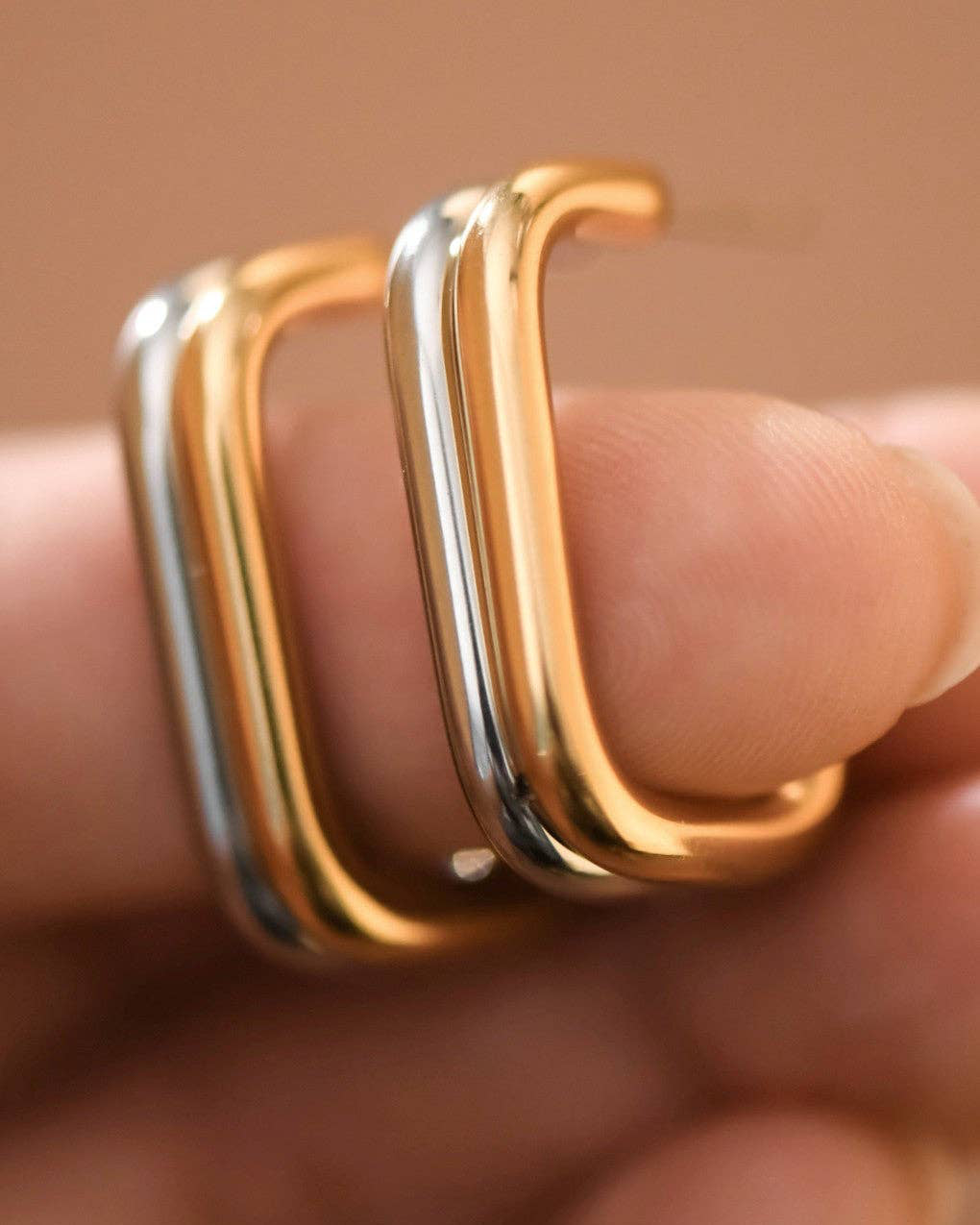 Three gold rings on a finger against a blurred background