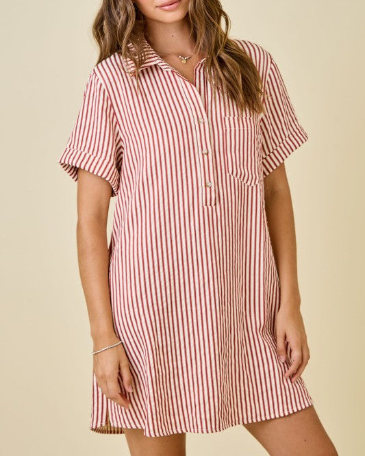 Woman wearing a red and white striped dress against a beige background