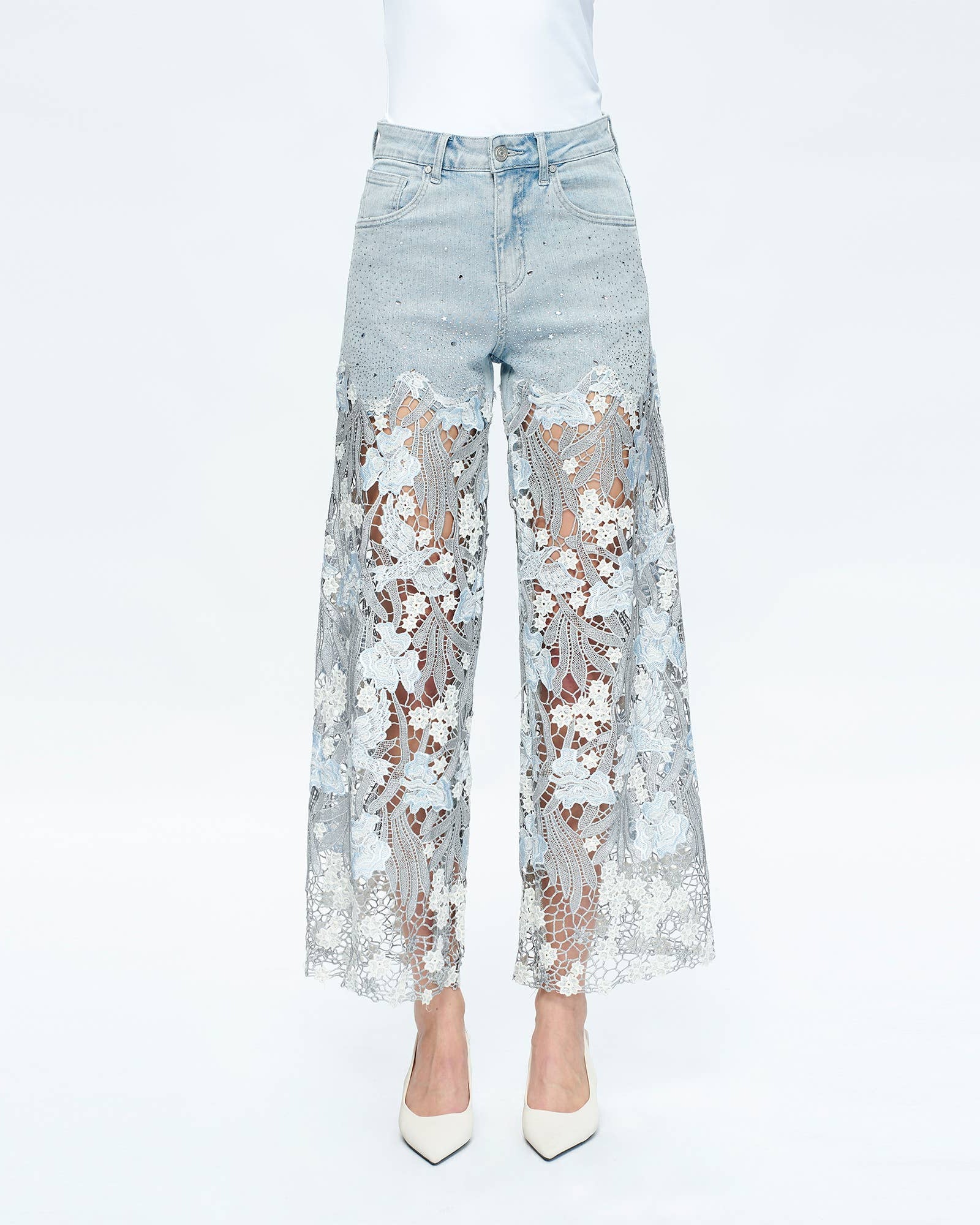 Light blue jeans with floral lace detailing on a white background