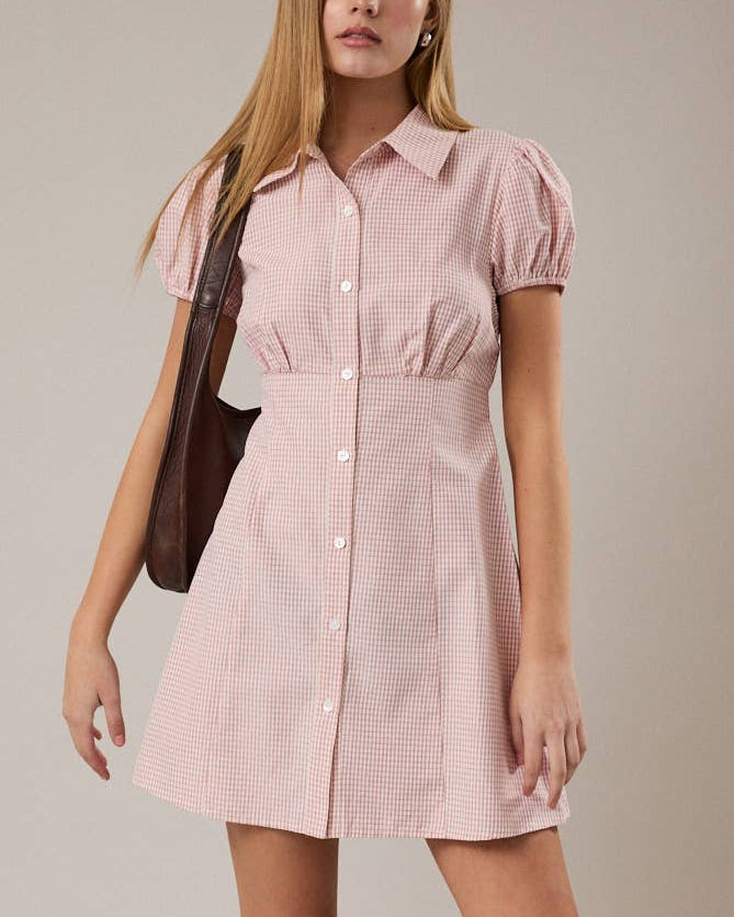 Woman wearing a pink dress with a plain background