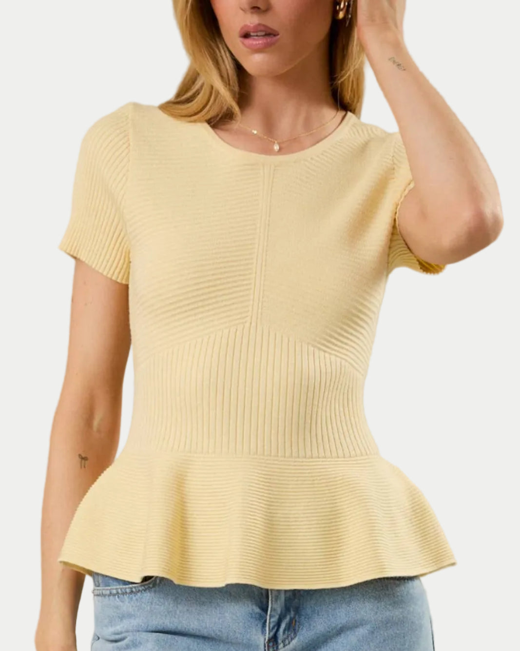 ROUND NECK SHORT SLEEVE PEPLUM RIBBED TOP IN BUTTER YELLOW ON A MODEL WITH A WHITE BACKGROUND- Blackbird Boutique