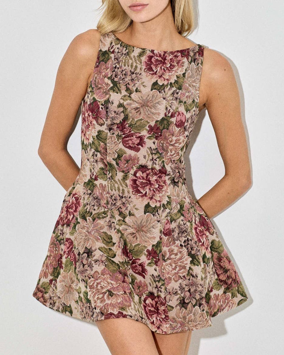 Woman wearing a floral dress against a plain background