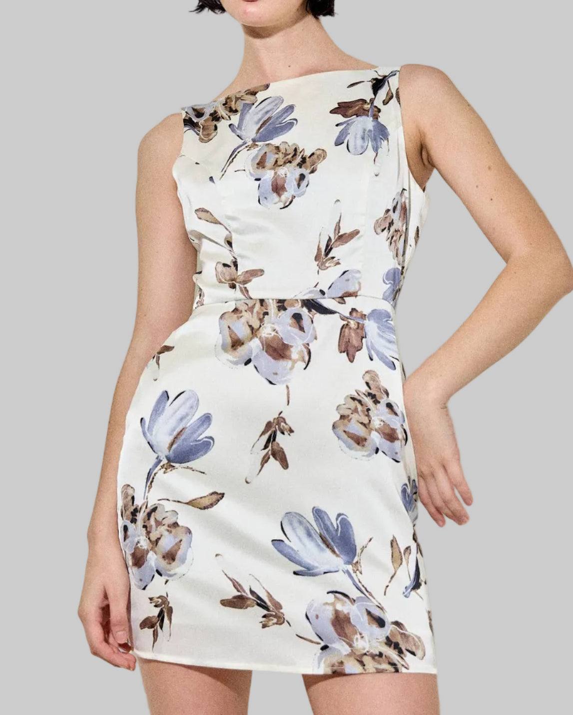 Woman wearing a floral dress against a plain background