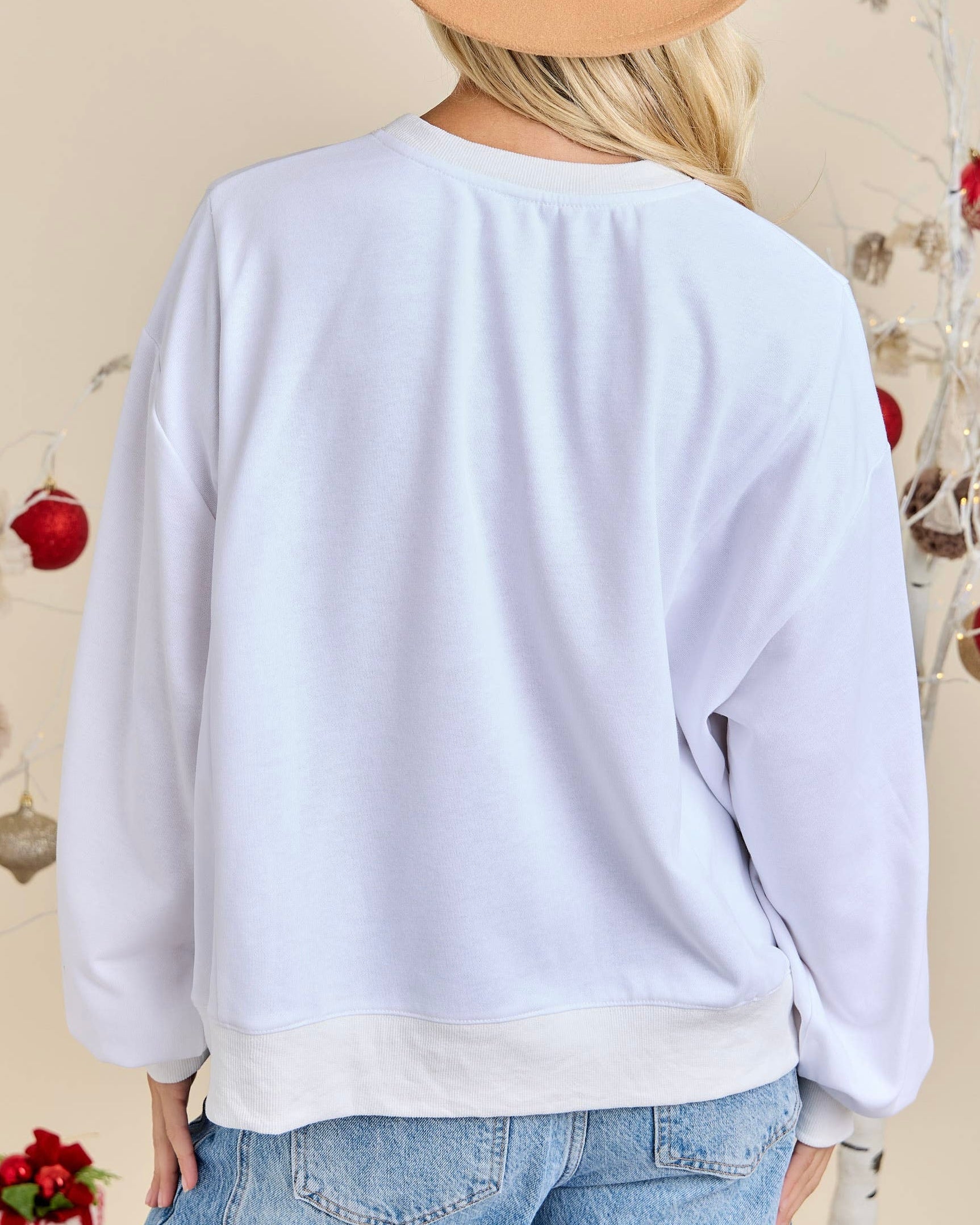 White sweatshirt worn by a person with a neutral background