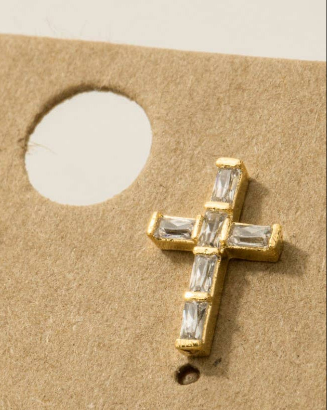 Gold cross earrings with clear stones on a cardboard backing