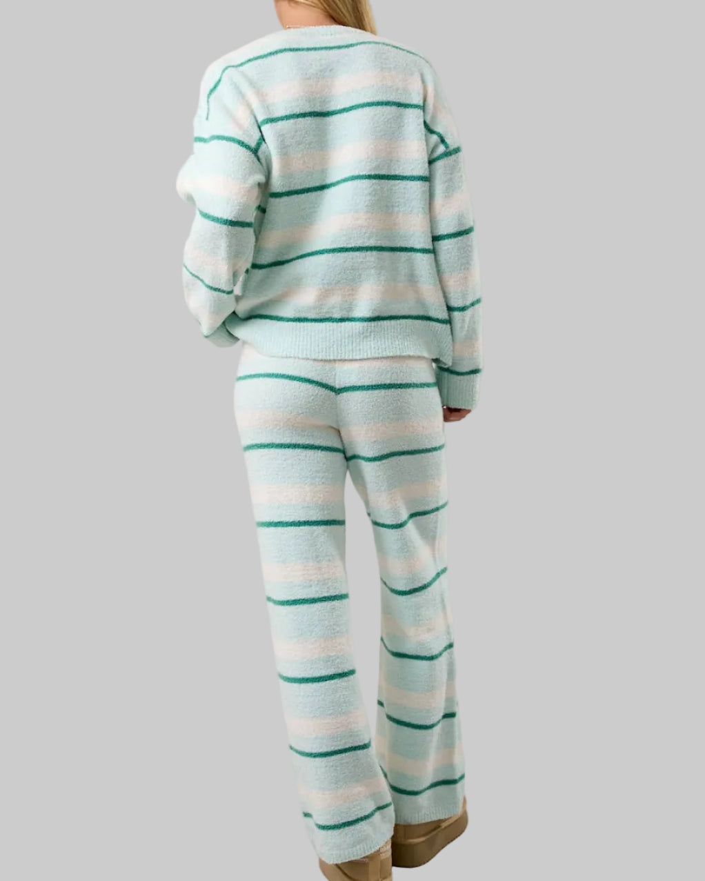 Person wearing a striped pajama set on a plain background
