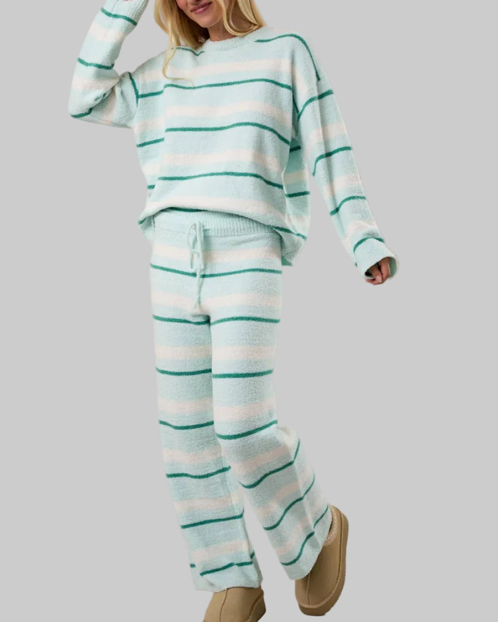 Woman wearing a striped pajama set with a plain background