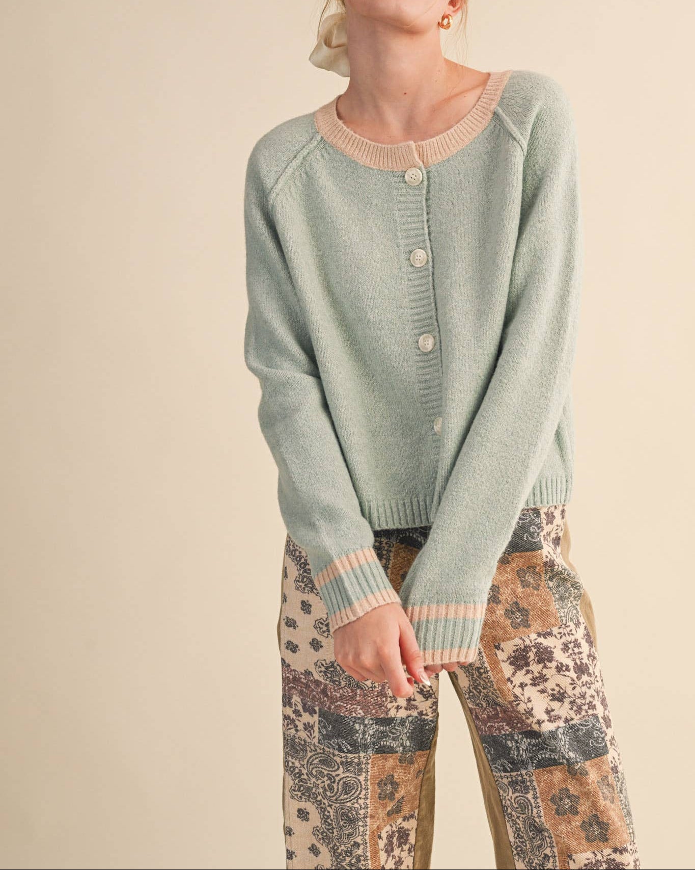 Woman wearing a light blue sweater with a beige background