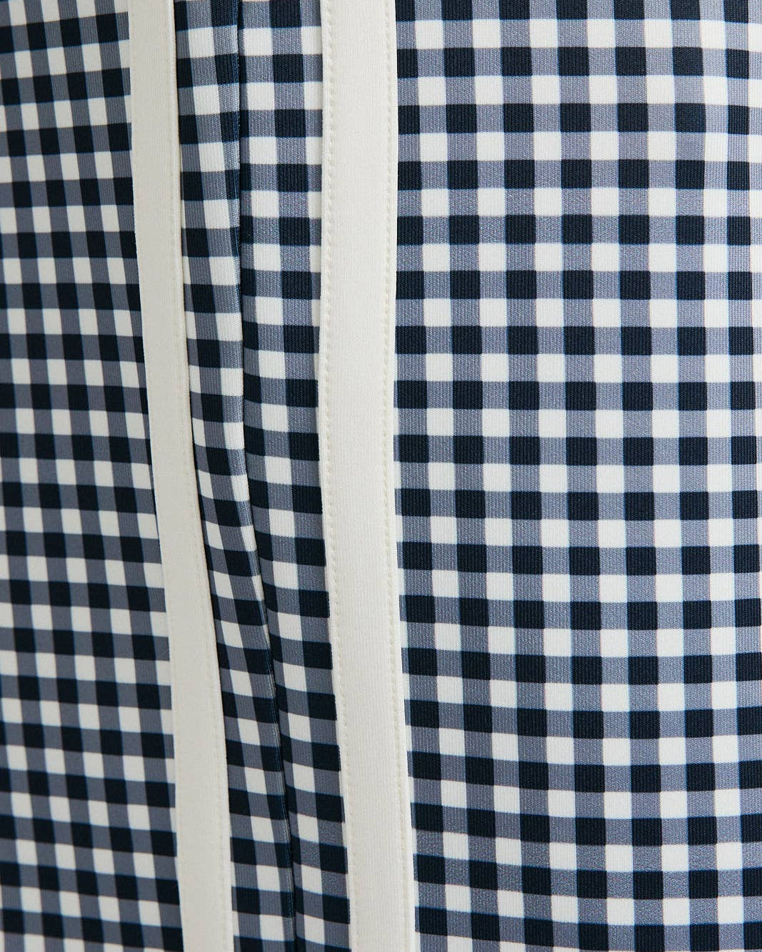 Close-up of a blue and white checkered fabric with a stripe pattern.