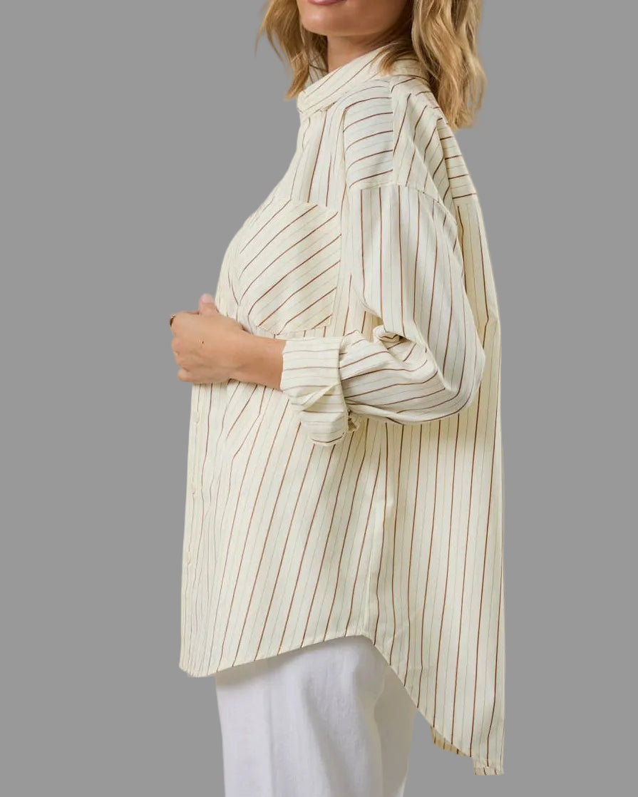 Woman wearing a long, light-colored striped shirt against a beige background
