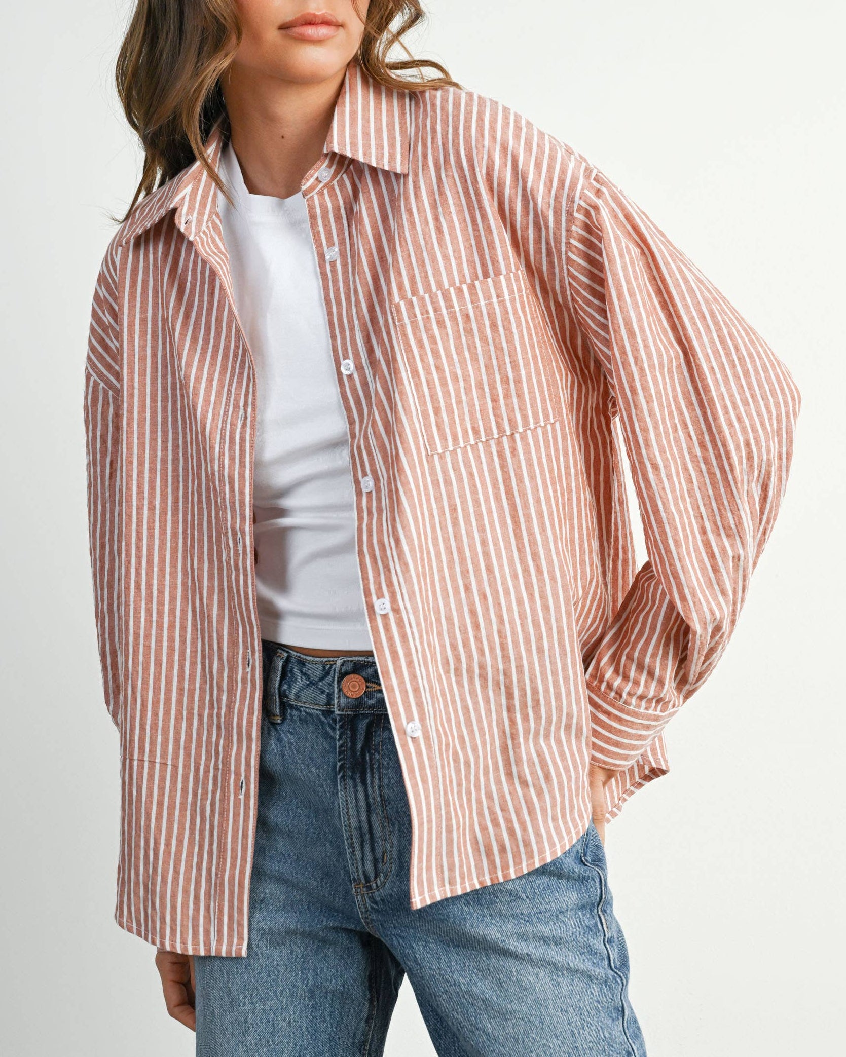 Woman wearing a striped shirt and jeans on a white background