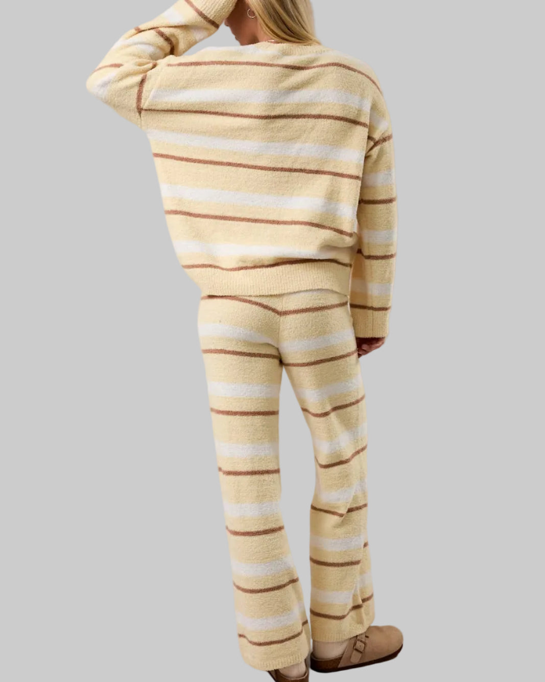 Person wearing a yellow and white striped outfit on a plain background