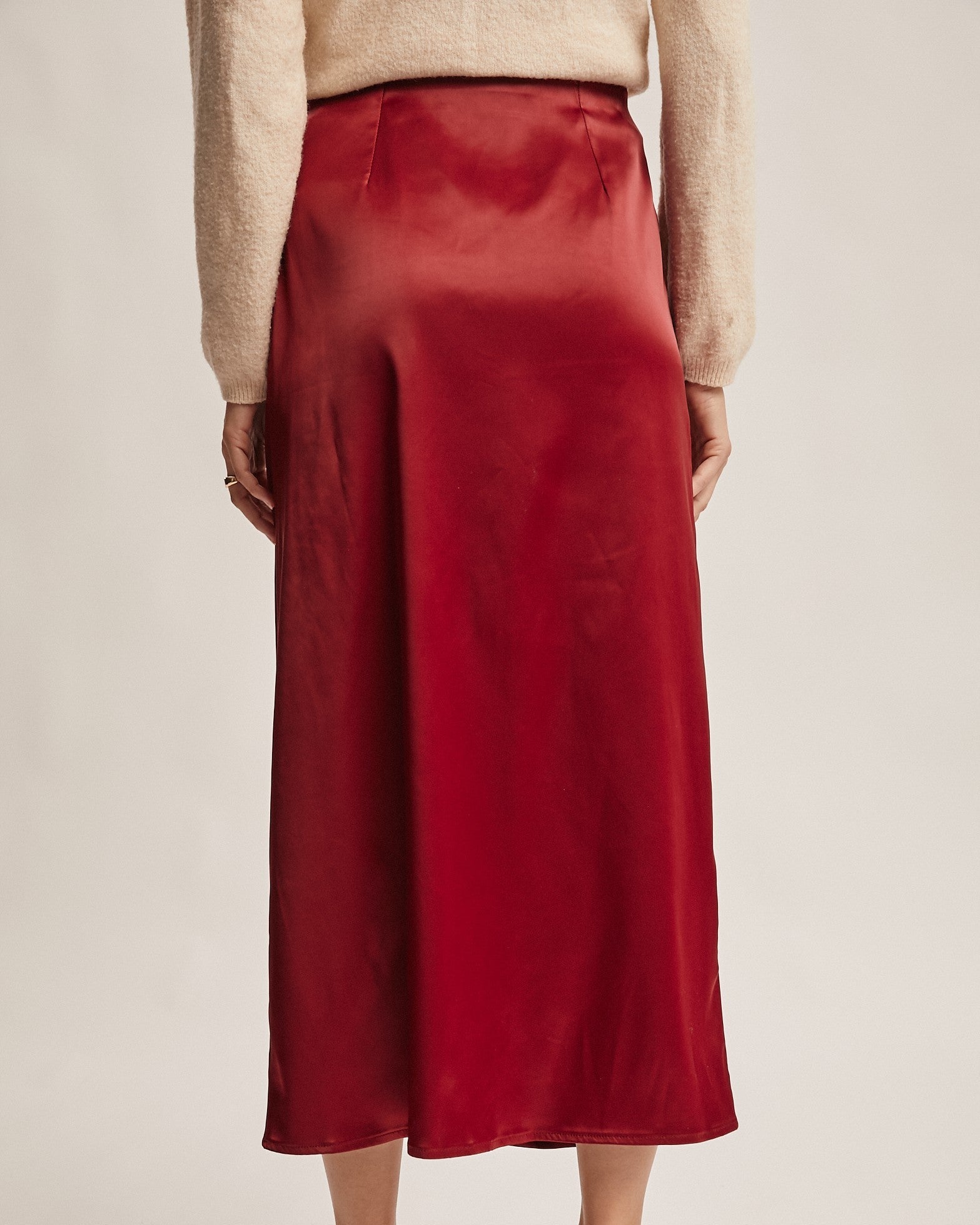 Red skirt worn by a person on a plain background