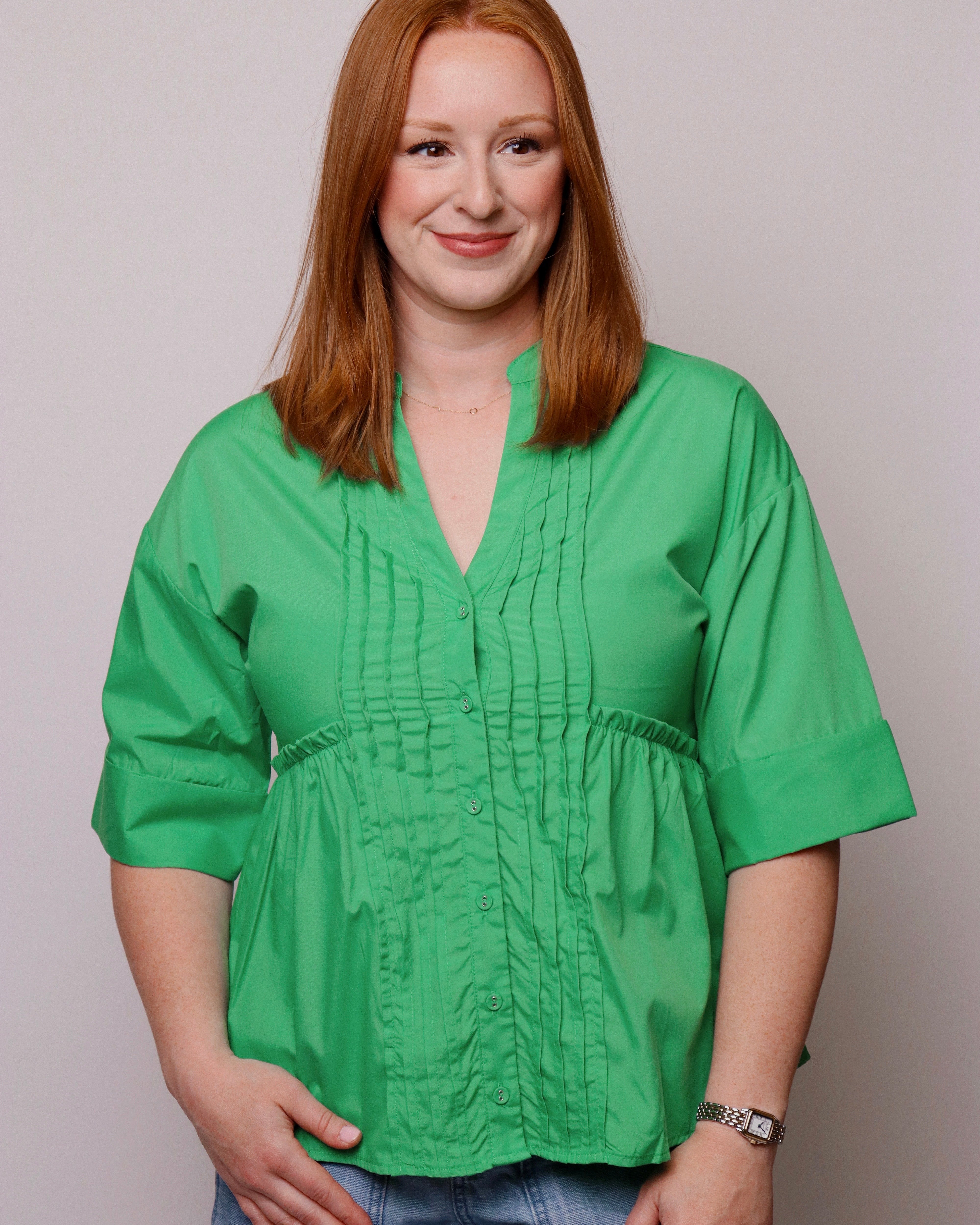 Woman wearing a green blouse against a plain background
