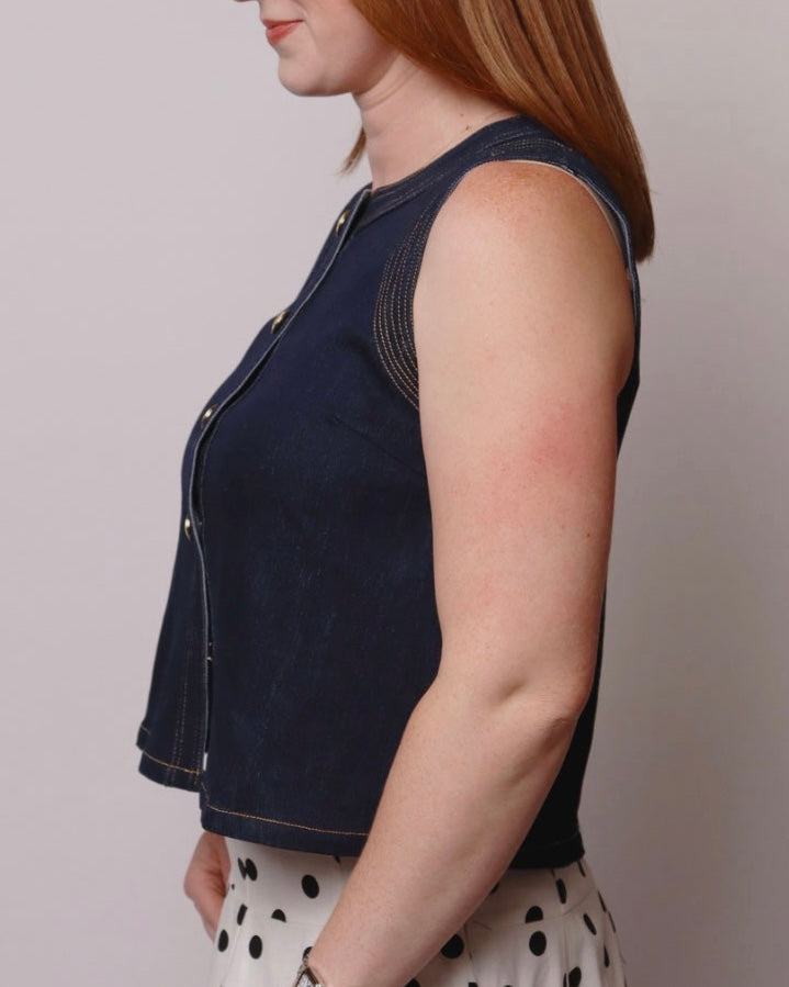 Person wearing a navy blue sleeveless top against a plain background