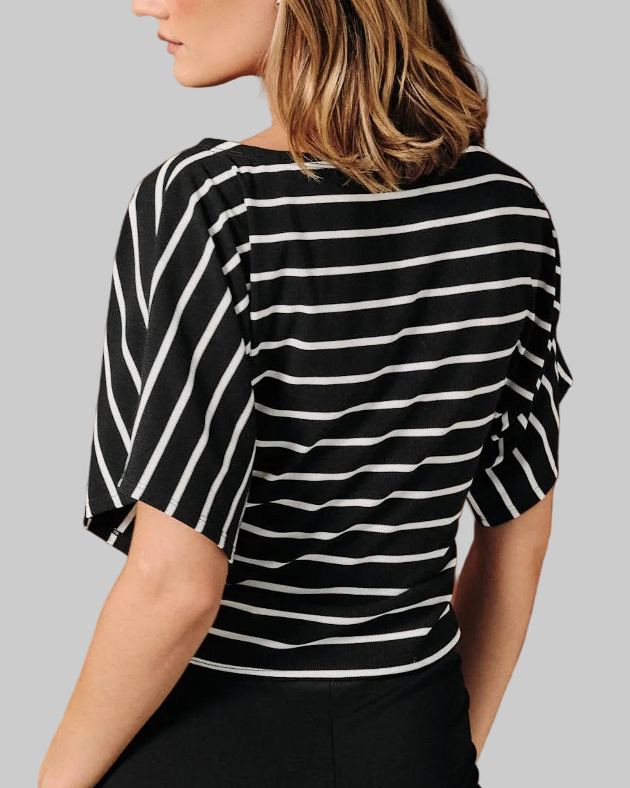 A model wearing a black and white horizontally striped short-sleeve top with dolman sleeves on a neutral background