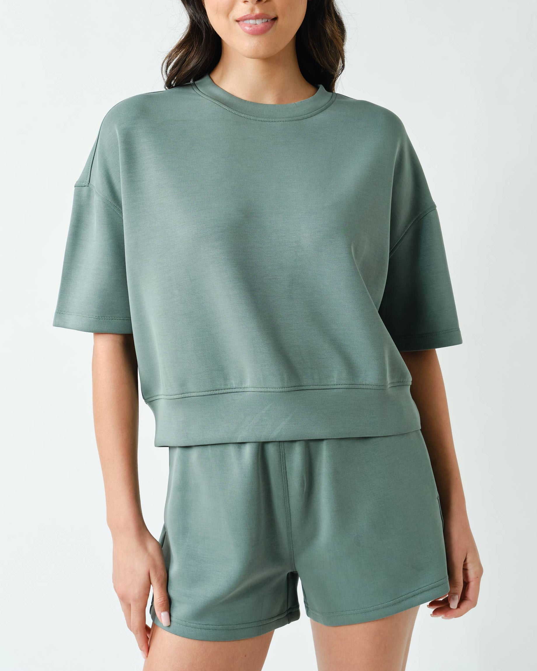 Model wearing a sage shorts set on a neutral background