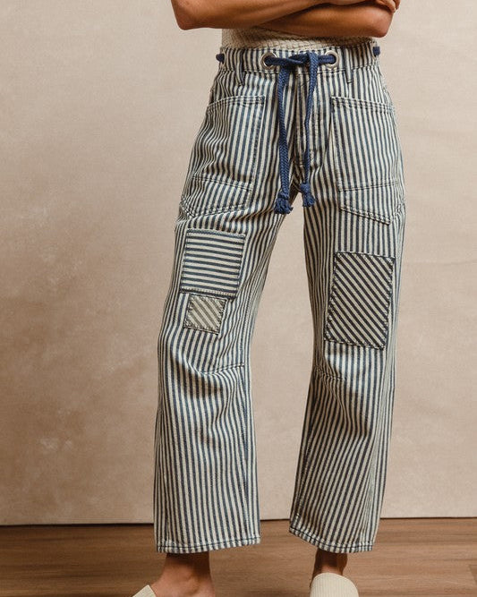 Person wearing striped wide-leg pants with a neutral background