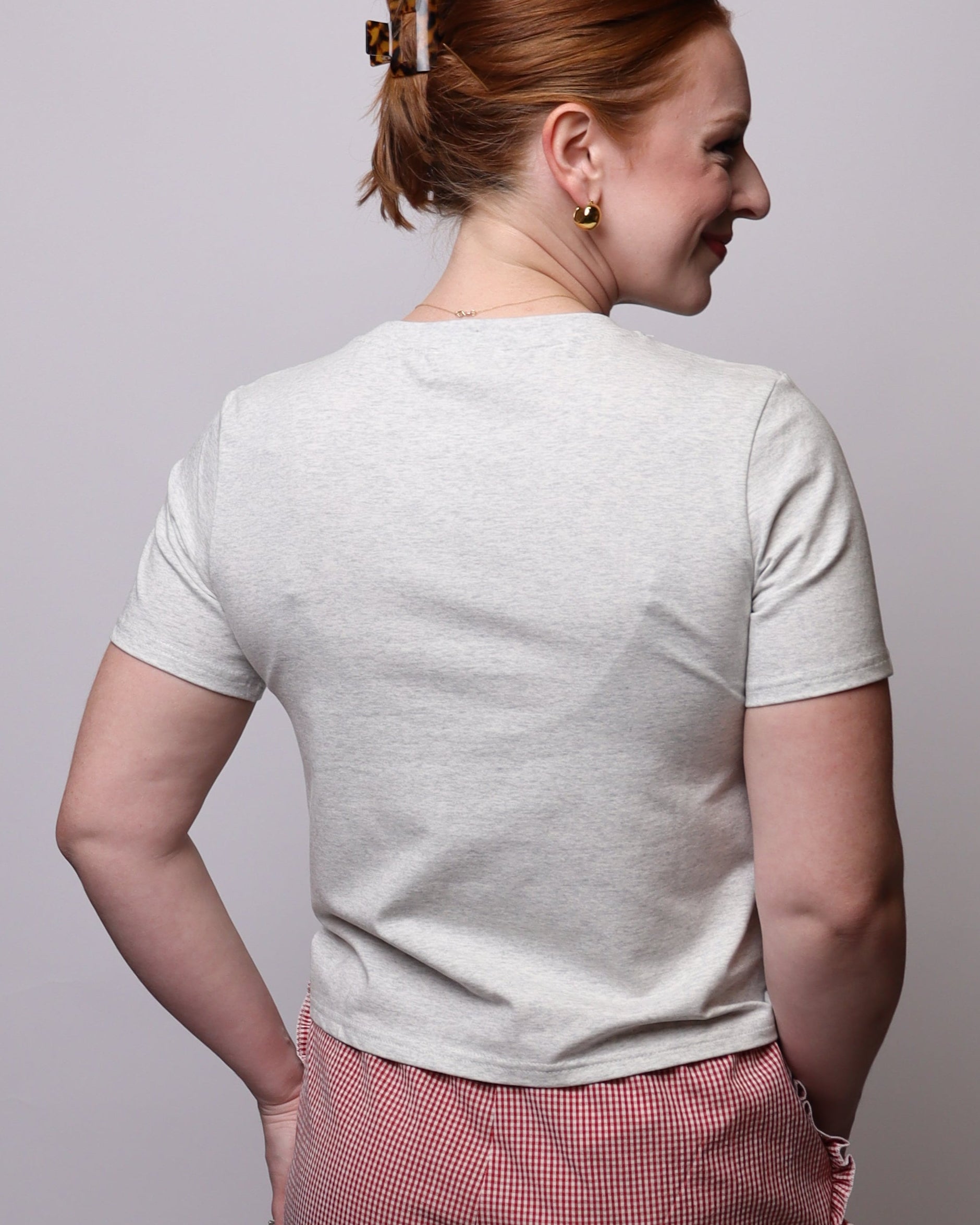 Person wearing a white shirt and pink shorts standing on a white platform.