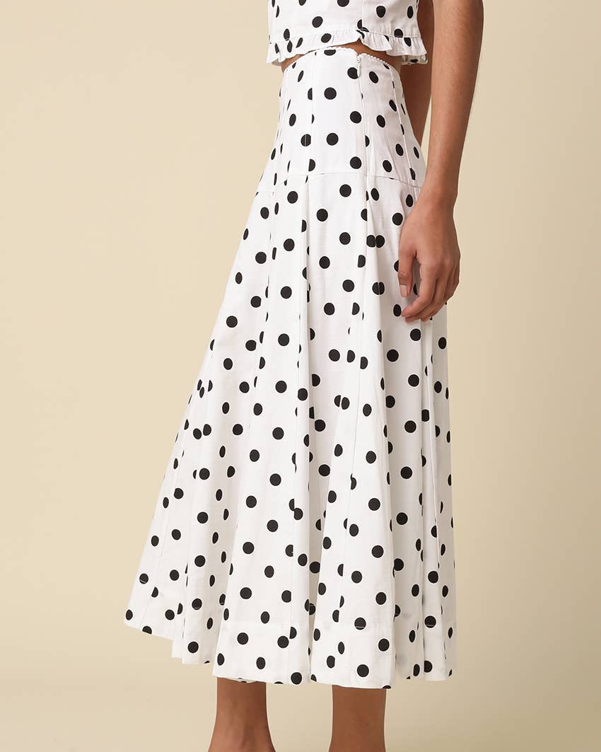 White with black Polka Dot Midi Skirt worn on a model with a neutral background- Blackbird Boutique side view