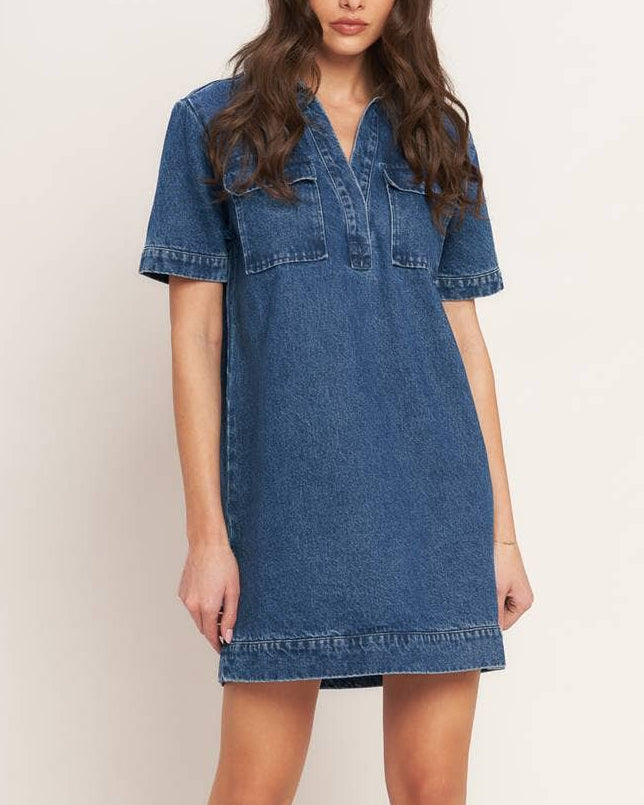 Model wearing a blue denim dress on a neutral background