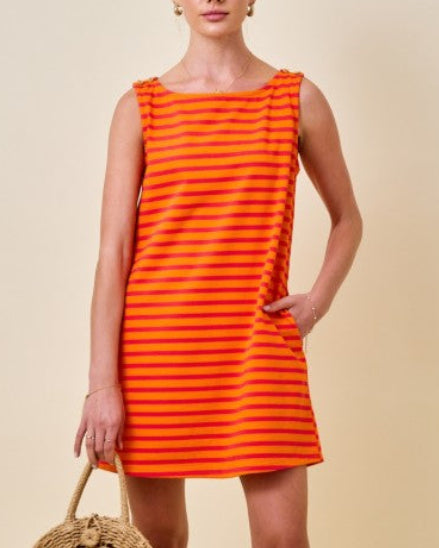 Woman wearing an orange and pink striped mini t-shirt dress on a neutral background