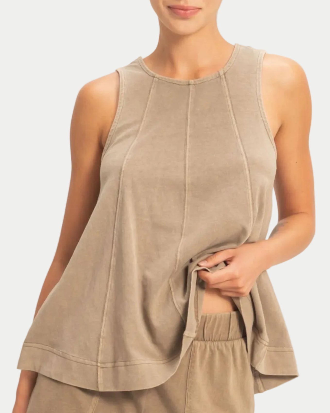 Woman wearing a mocha sleeveless swing top on a neutral background. front view