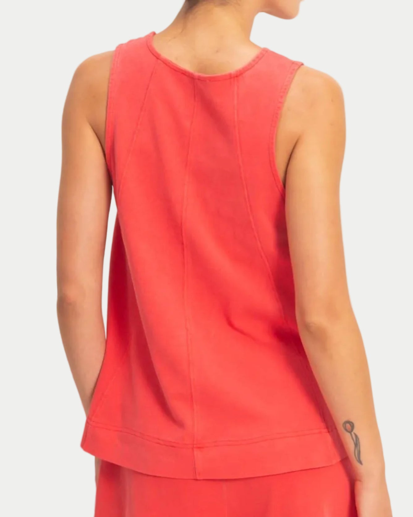 Woman wearing a red sleeveless swing top on a neutral background. front view