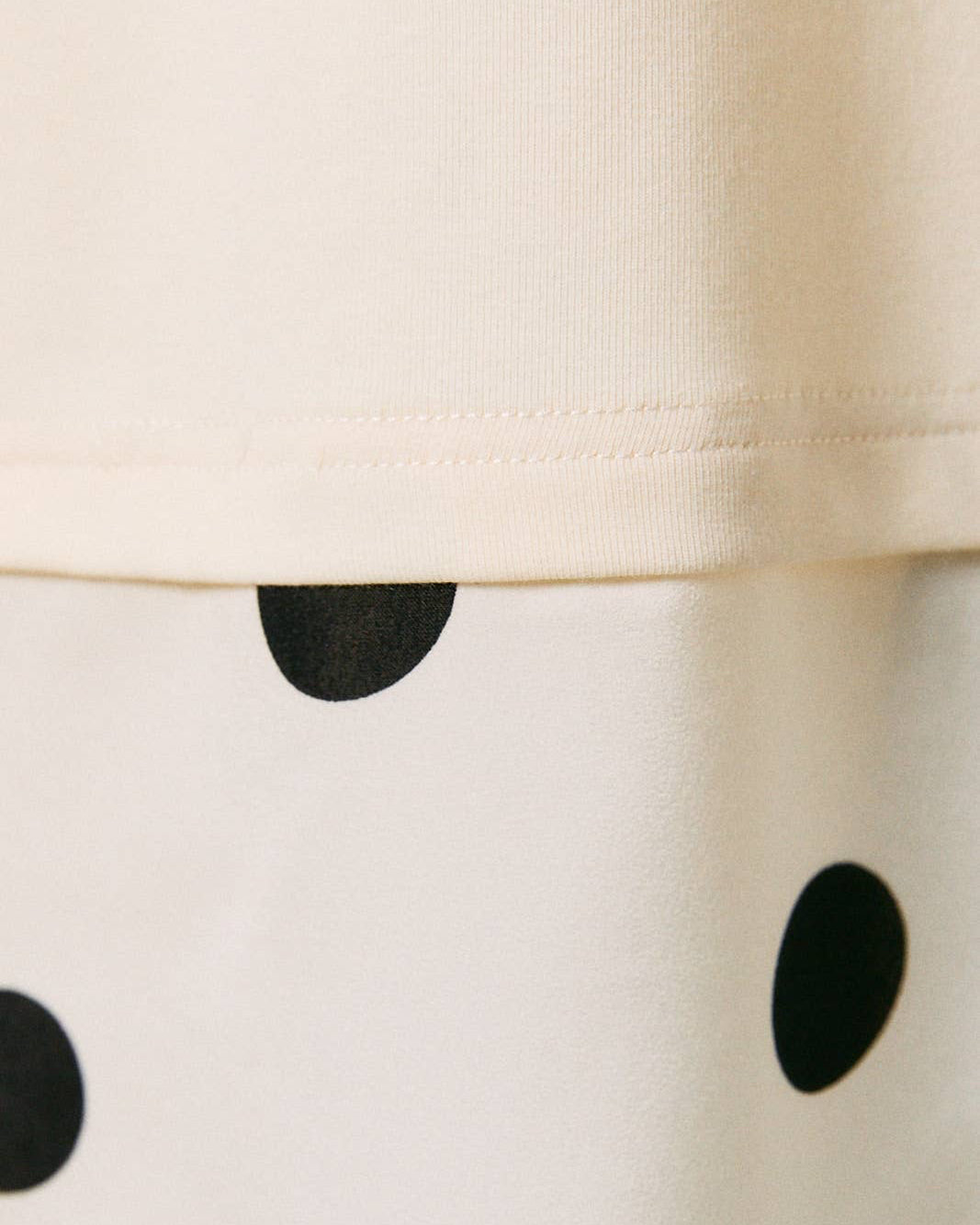 Close-up of a white garment with black polka dots