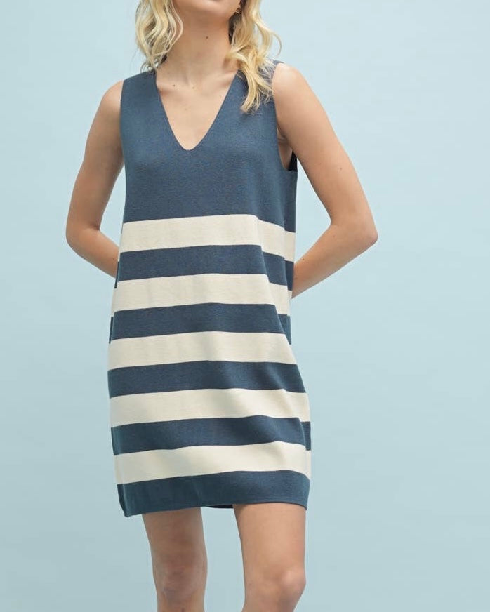 Woman wearing a blue and white striped dress against a light blue background