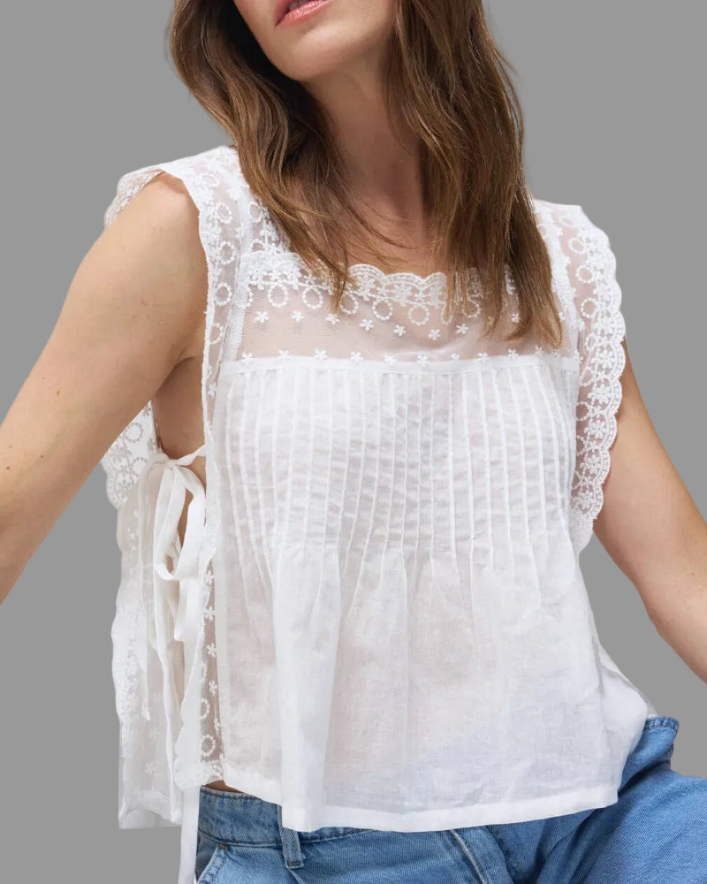 Model wearing the Daisy white lace top on a neutral background