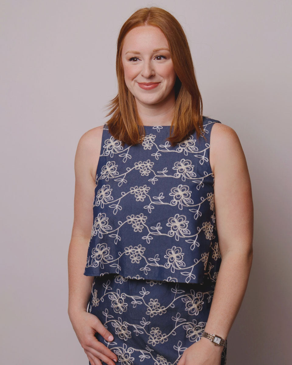 Woman wearing a blue floral top against a plain background