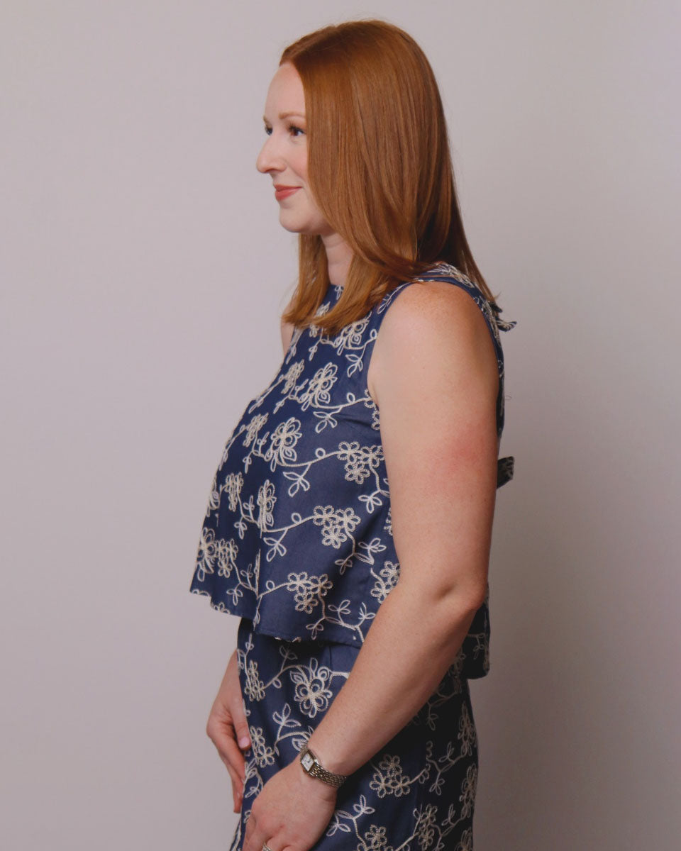 Woman wearing a blue floral top against a plain background