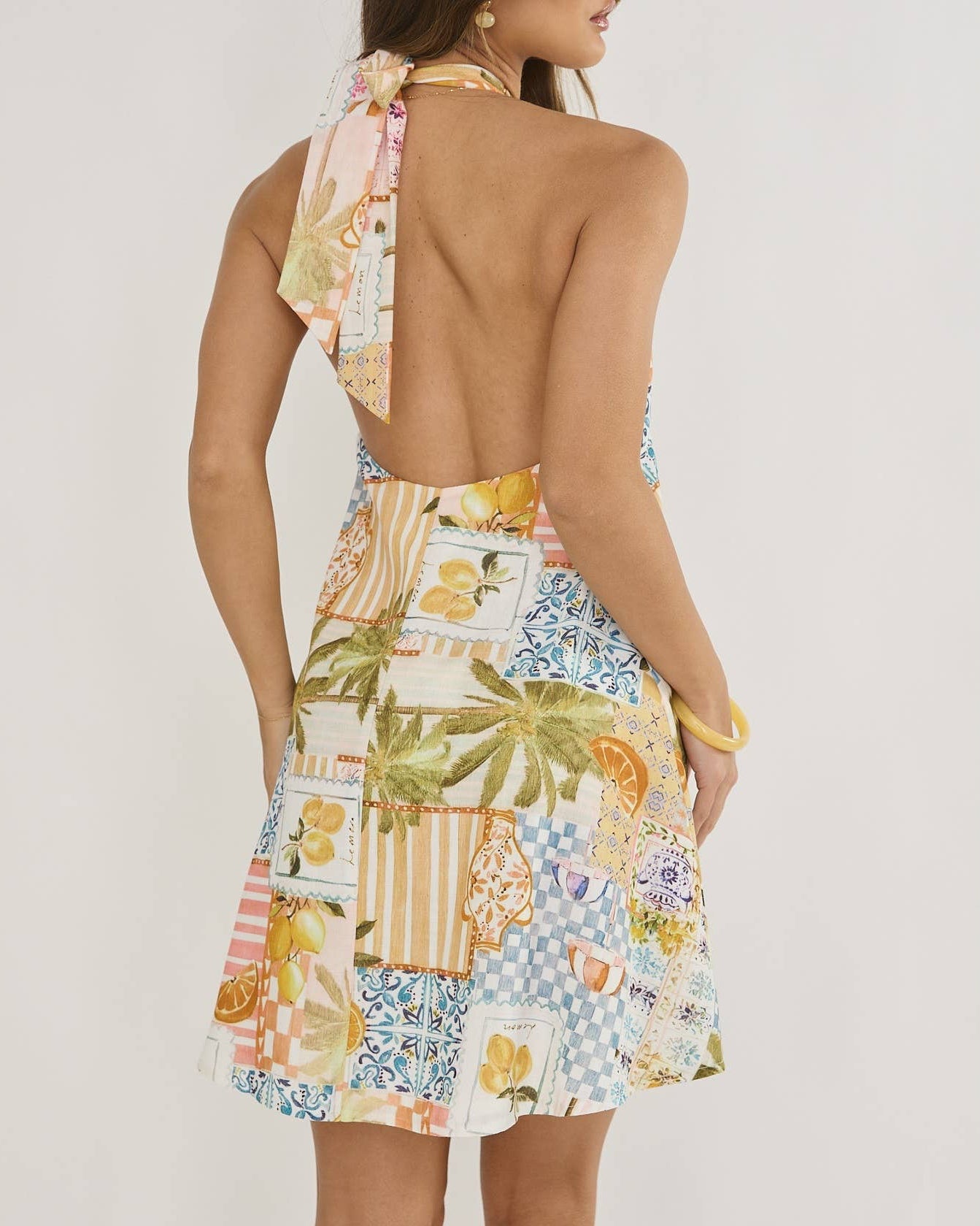 Woman wearing a colorful patterned dress with a white background