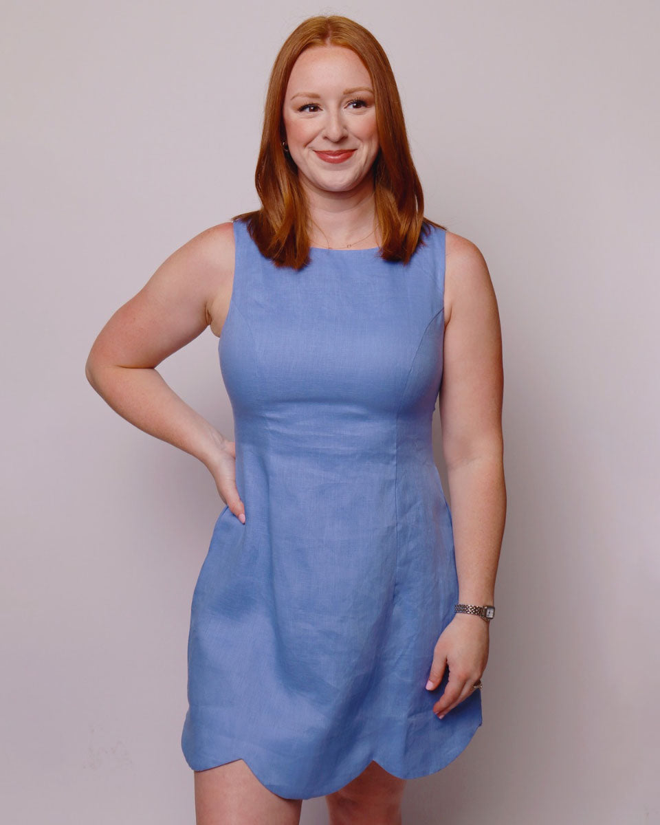 Woman wearing a blue dress against a plain background