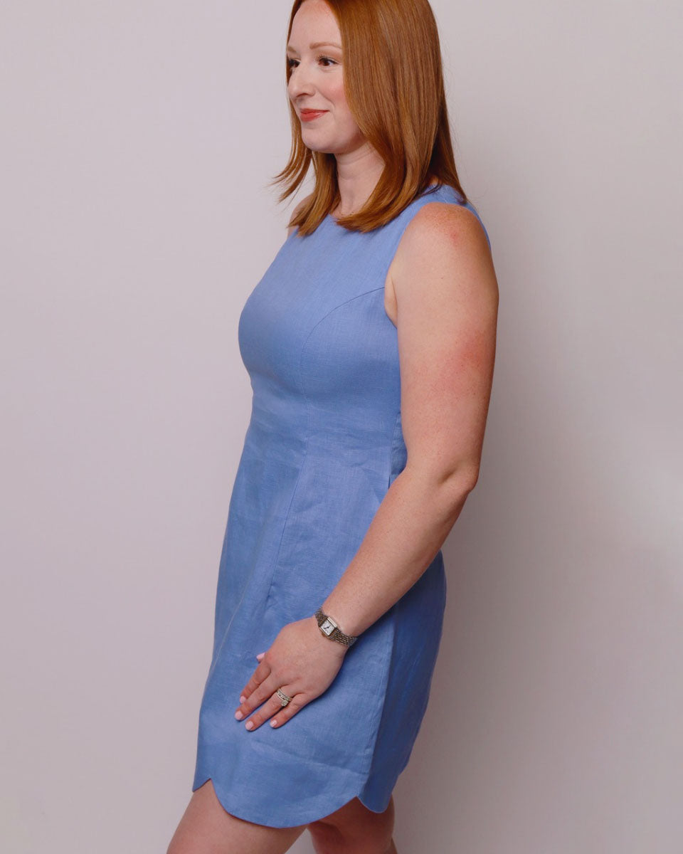 Woman wearing a blue dress against a plain background