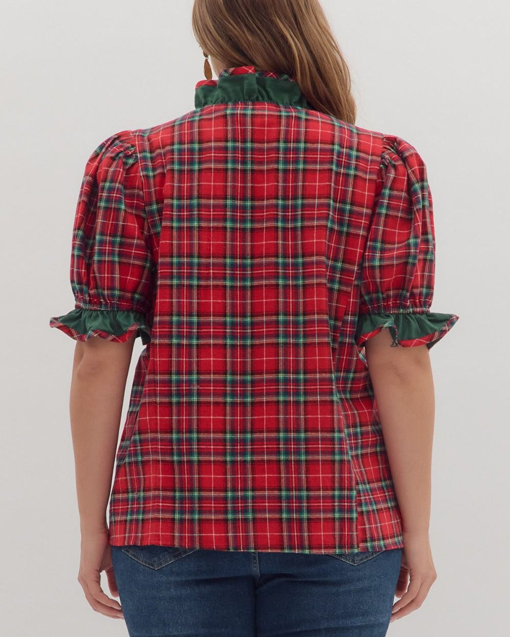 Red plaid shirt with green trim on a plain background