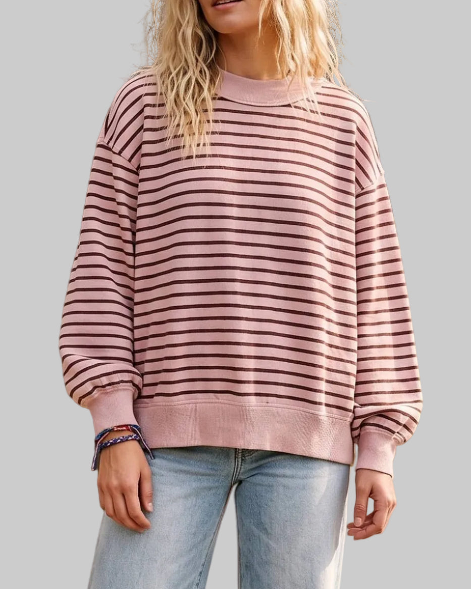 Model wearing a dusty pink sweashirt with brown stripes on a neutral background.