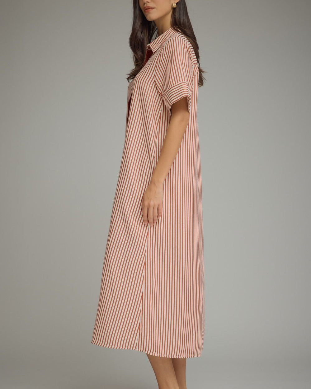 Woman wearing a red and white striped dress against a plain background
