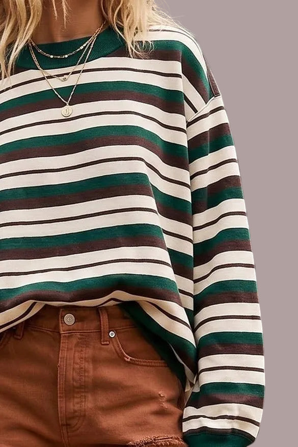 A model wearing a striped sweatshirt in brown, cream and hunter green on a neutral background close up