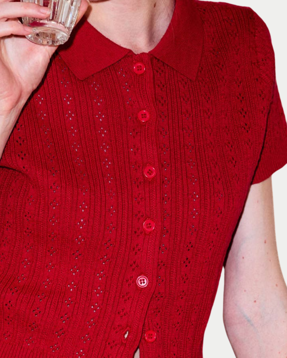 Red knitted cardigan with a patterned design on a plain background