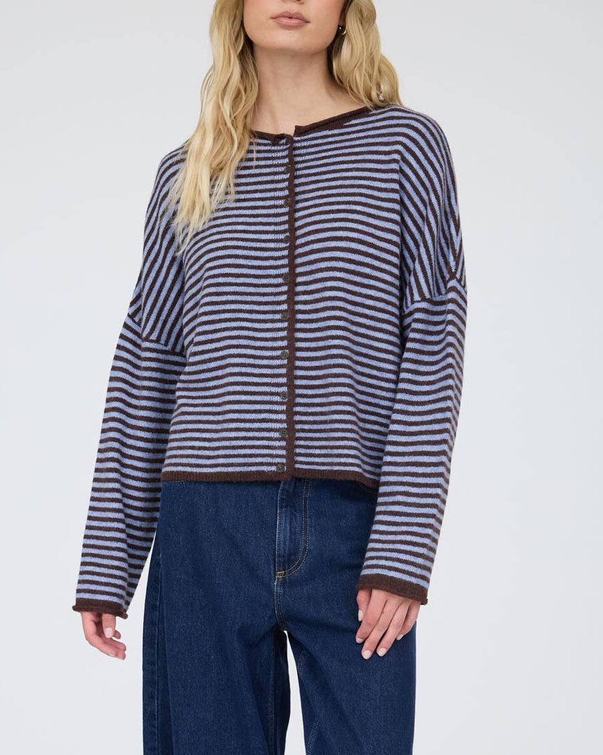 Woman wearing a striped sweater and wide-leg jeans on a white background
