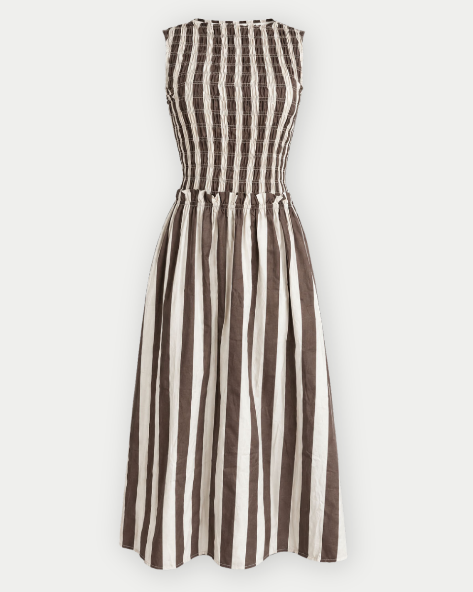 A sleeveless smocked dress with vertical brown and off-white stripes, shown against a plain light gray background.