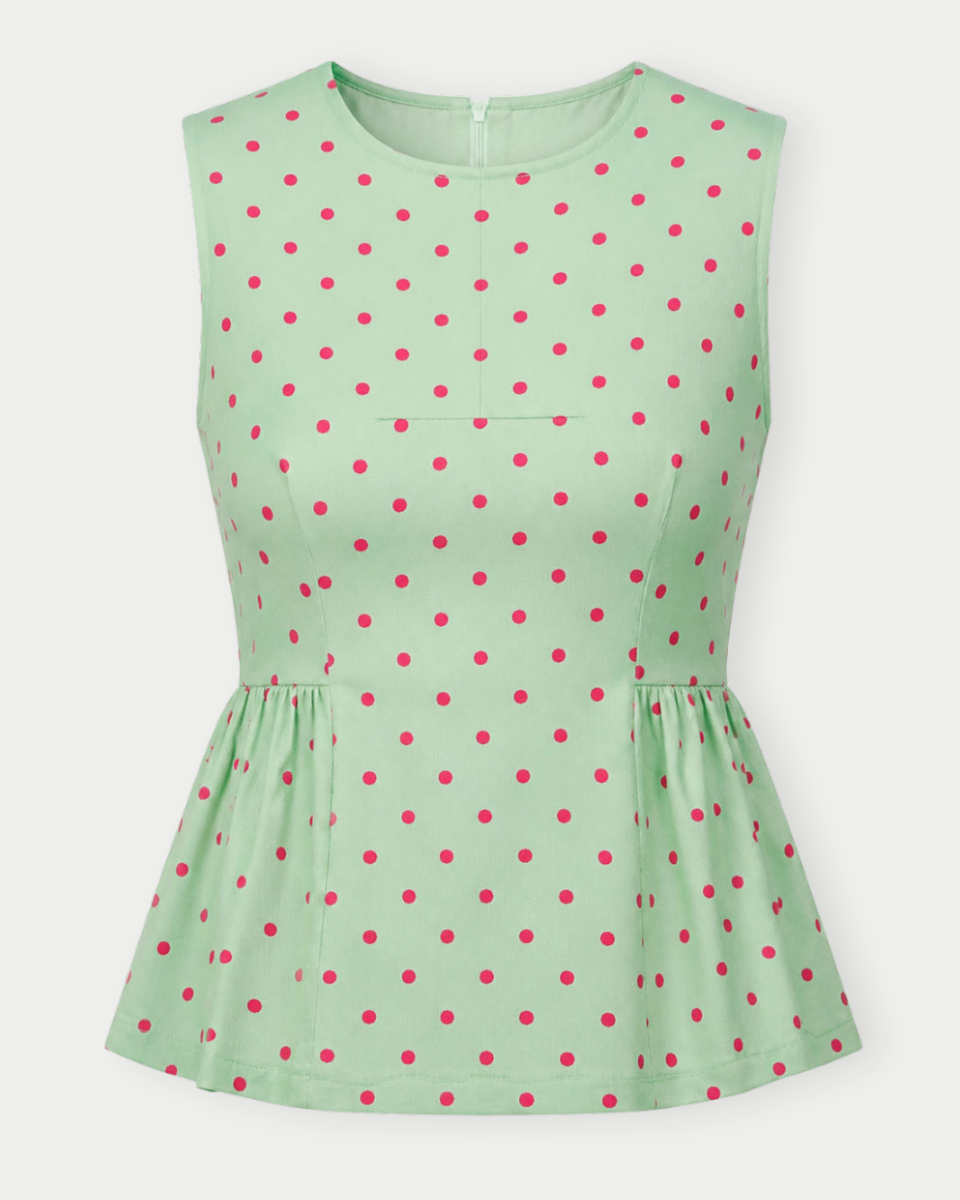 Green sleeveless top with red polka dots on a white background