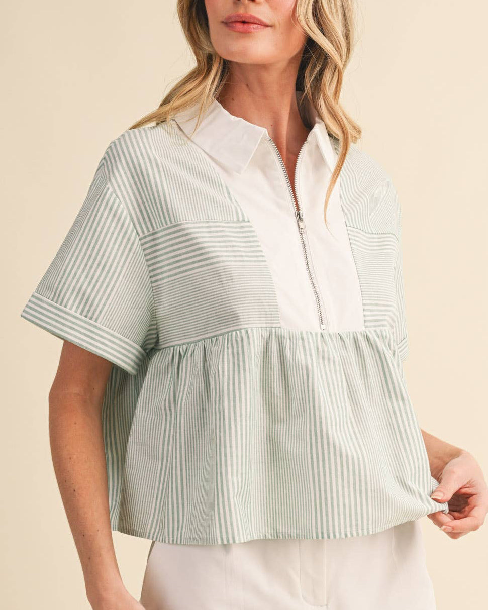 Woman wearing a light green and white striped shirt with white shorts on a beige background