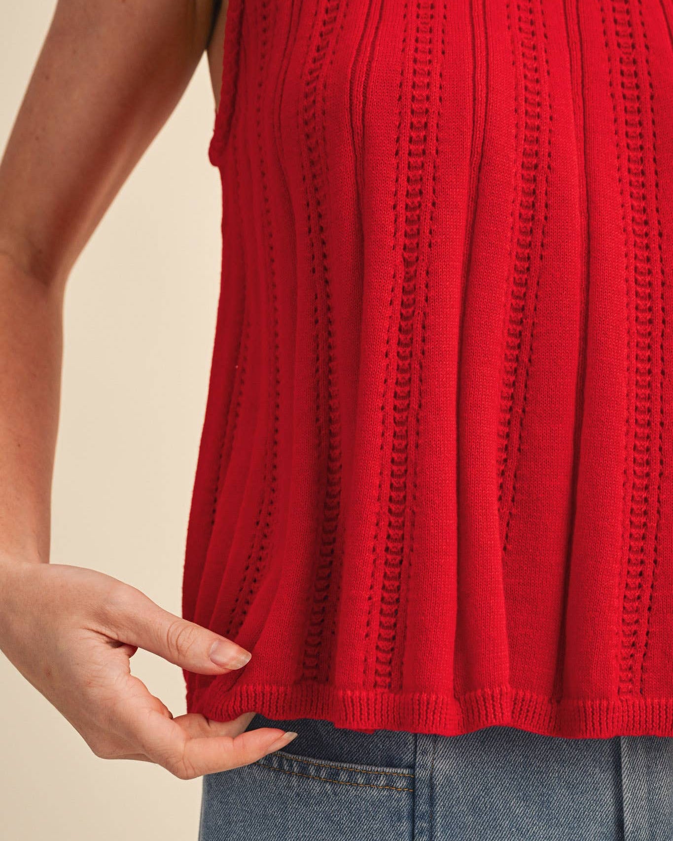 Red sleeveless top worn by a person with a beige background