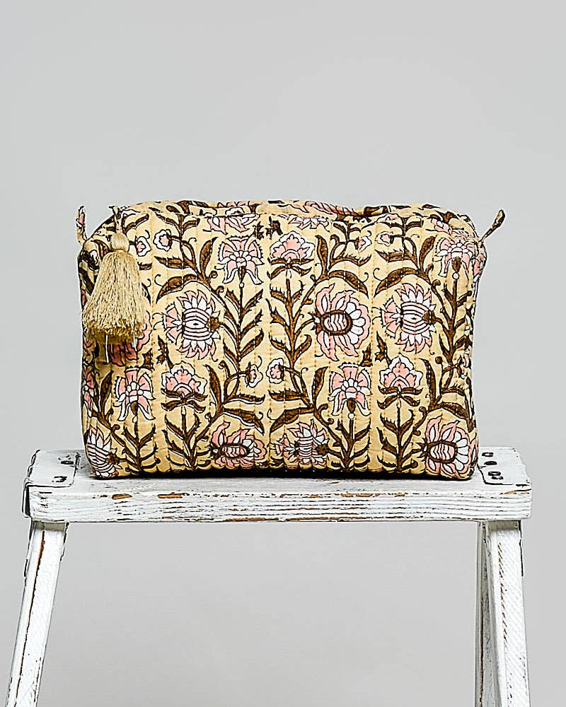 Floral patterned bag on a white stool against a light gray background