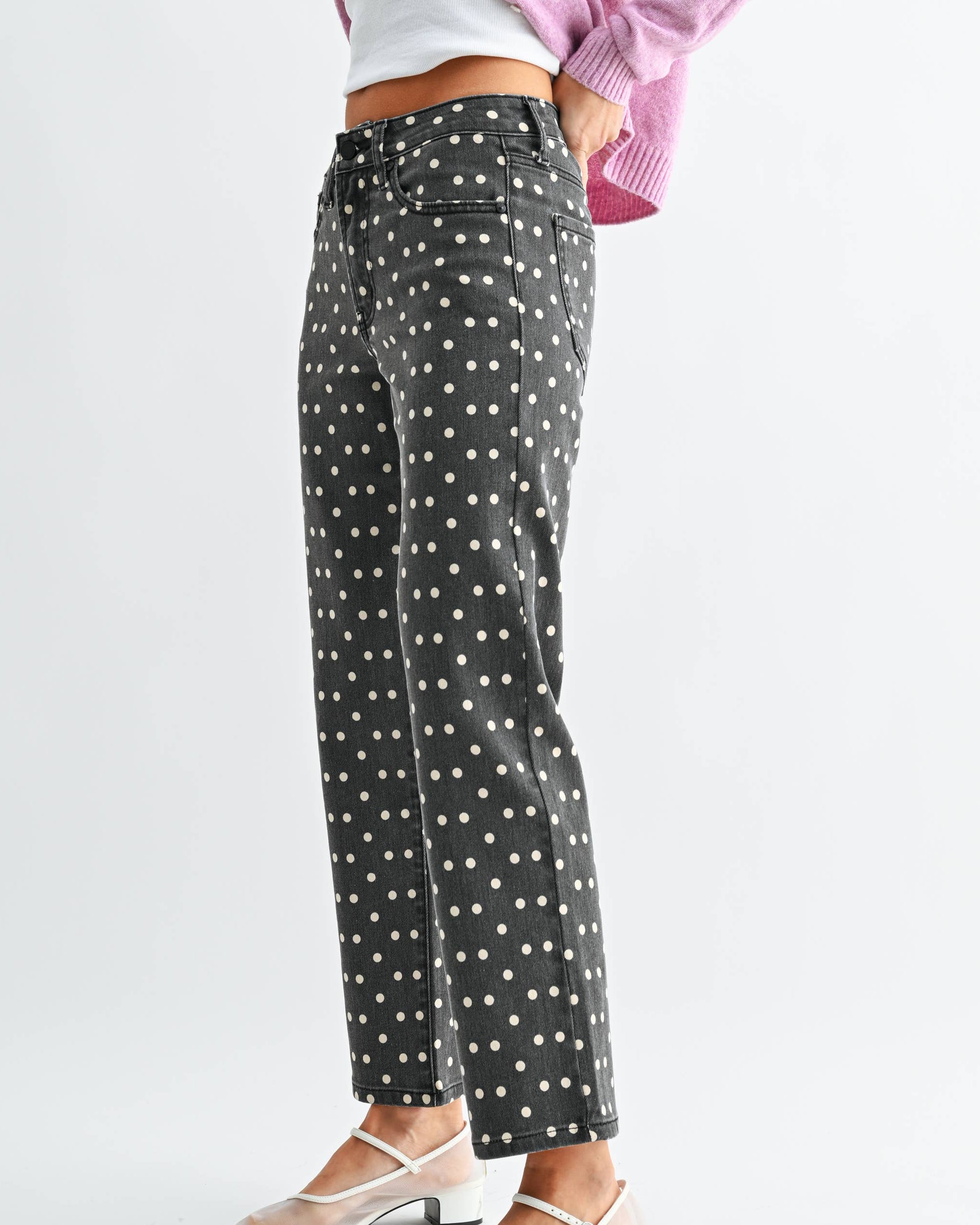 Vintage Black jeans with white polka dots worn by a model on a neutral background side view